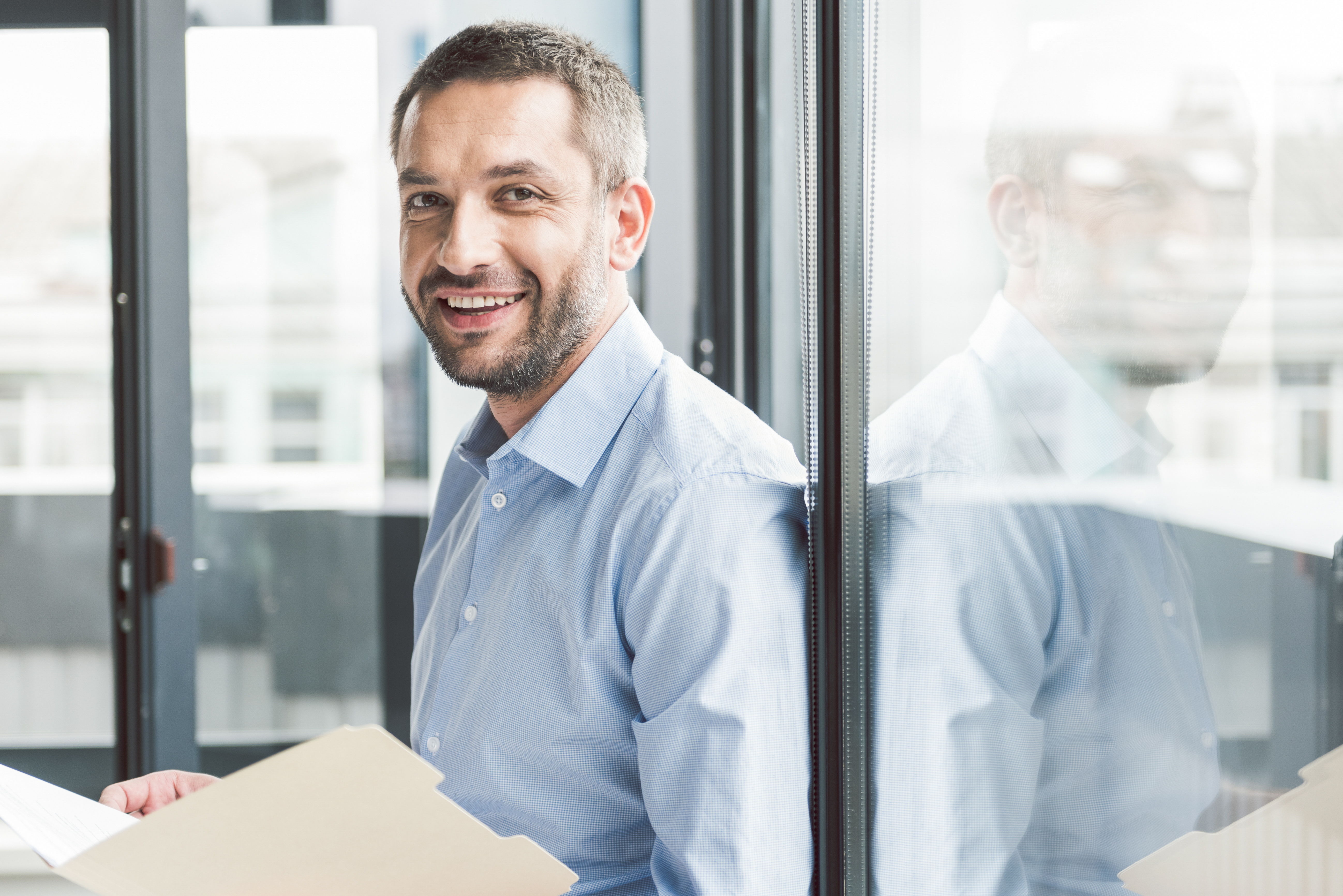 Glad smiling businessman holding papers