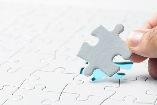 hand placing final puzzle piece representing Optima's personalized solutions hand placing final puzzle piece representing Optima's personalized solutions